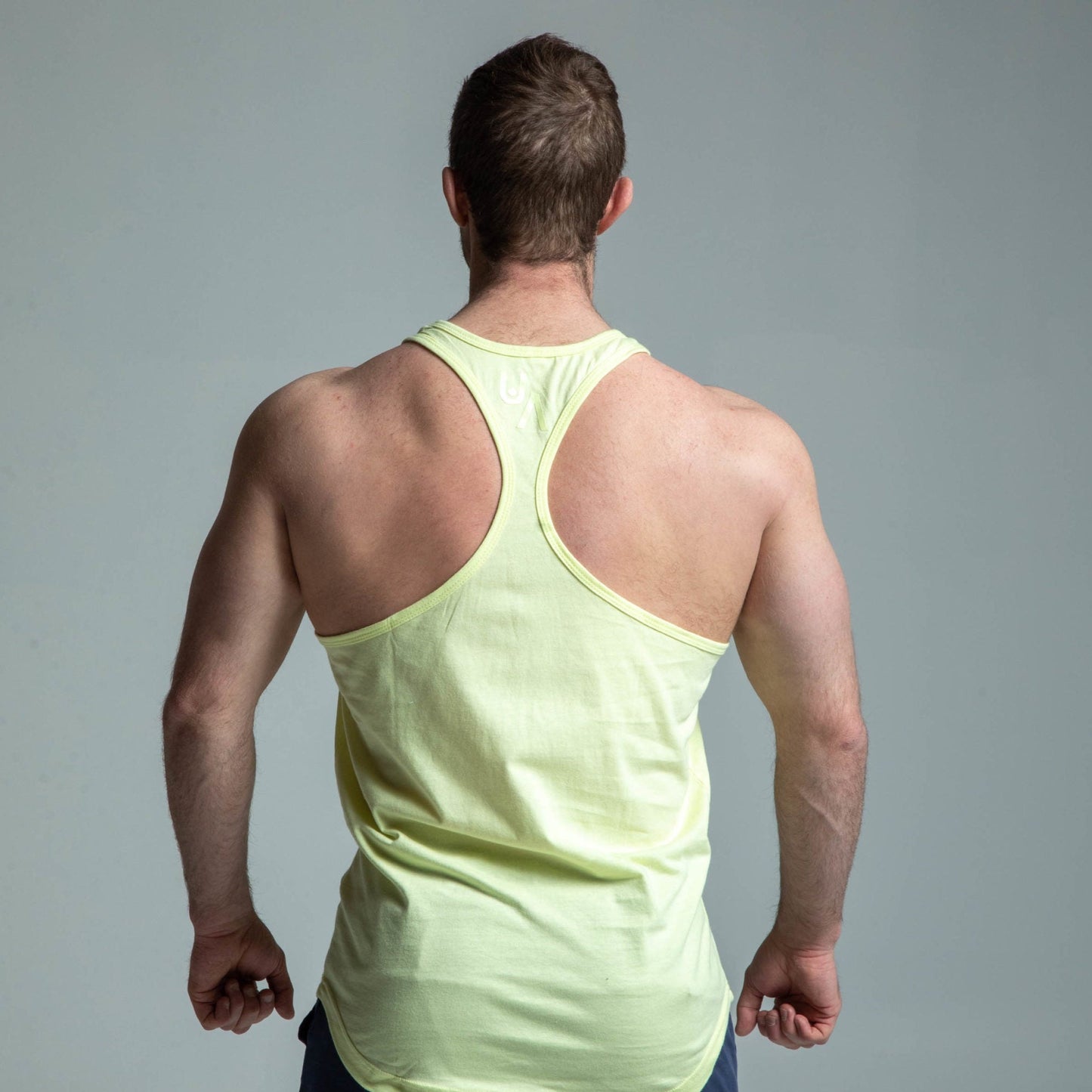 Back view of man wearing yellow glow stringer tank top