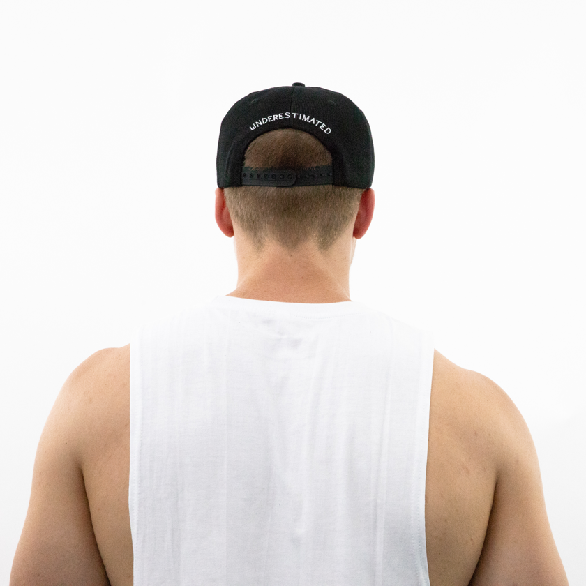 Back view of man wearing black Underestimated Apparel hat