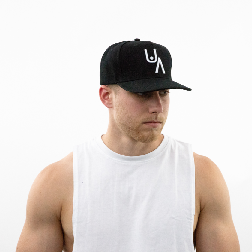 Man wearing black Underestimated Apparel hat