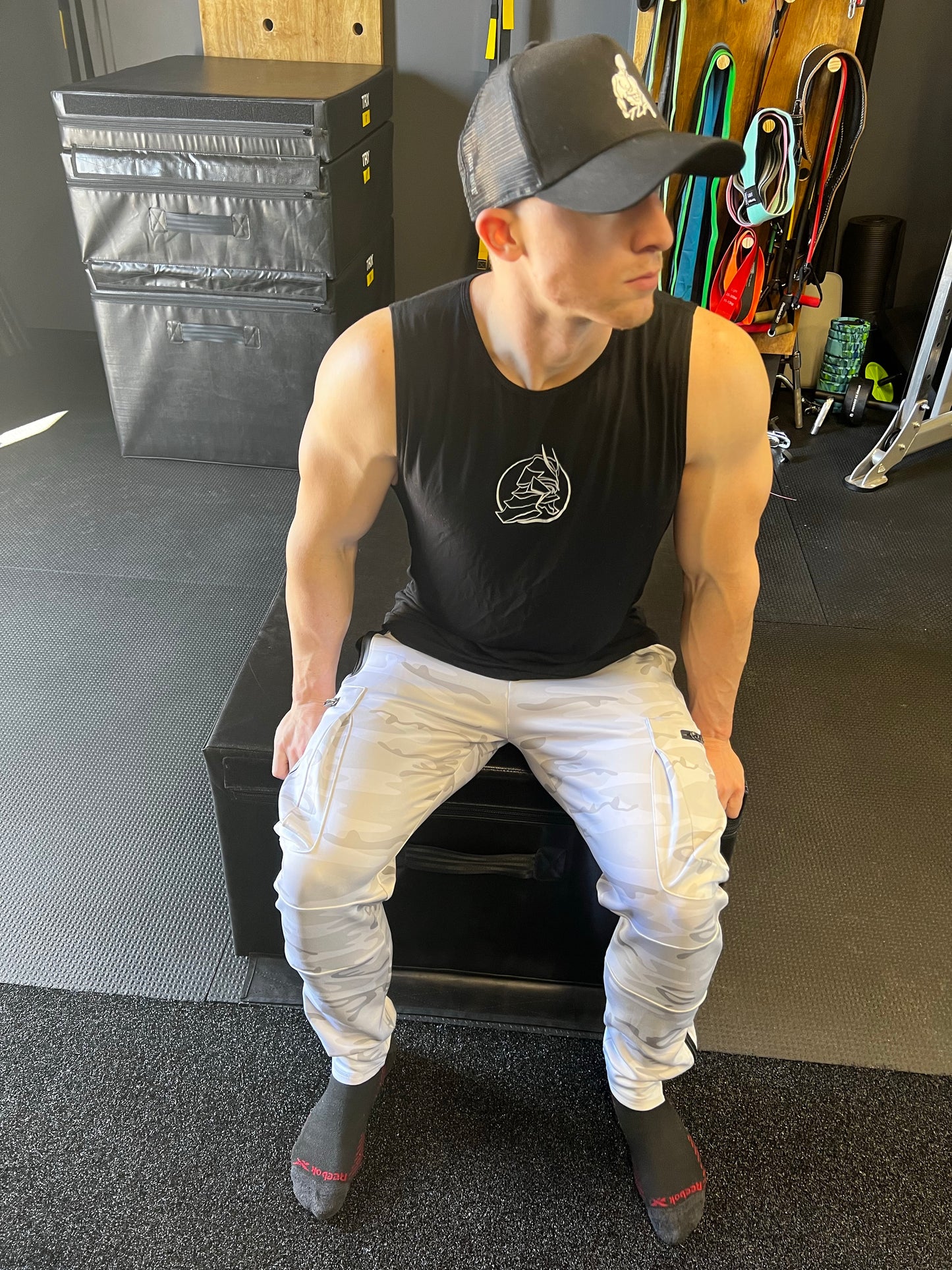 Man sitting in white camo warrior joggers.