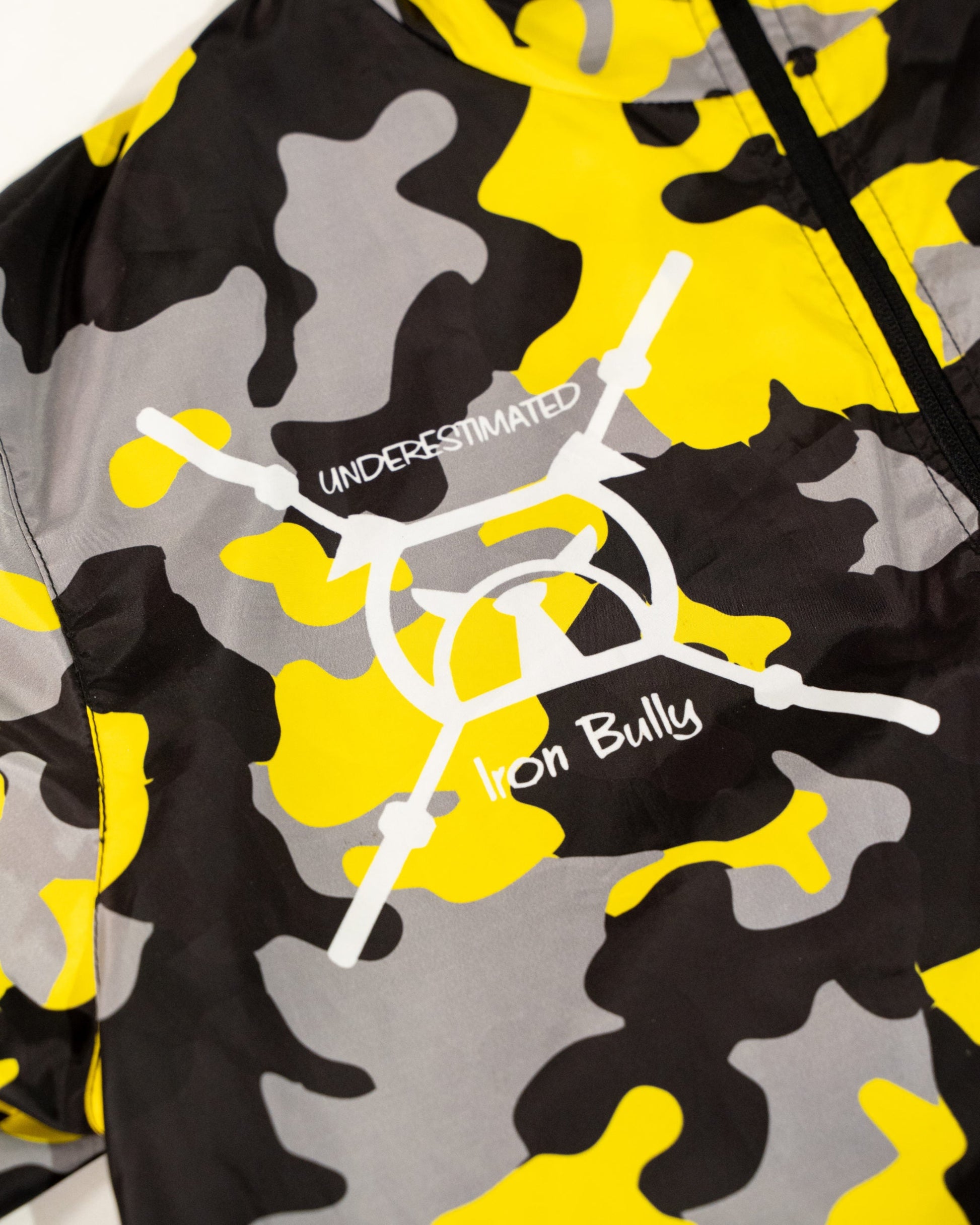 Closeup shot of outlined bulldog logo on yellow and gray grind camo windbreaker