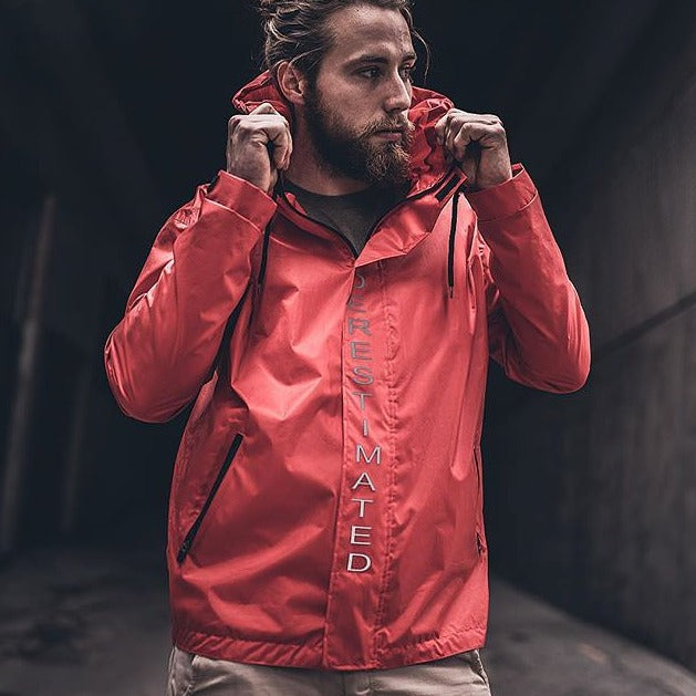 man holding hoody of red all-weather tech jacket