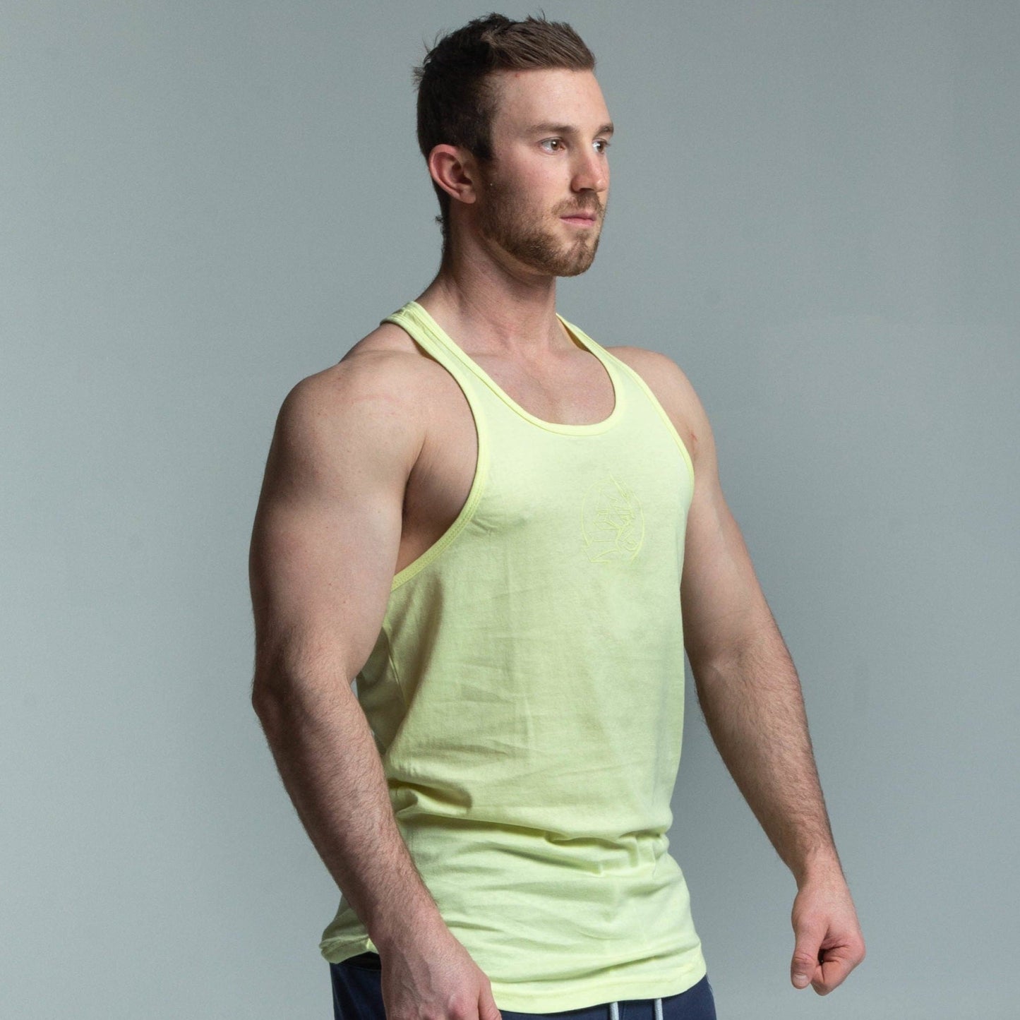 Angled view of muscular man wearing yellow glow stringer