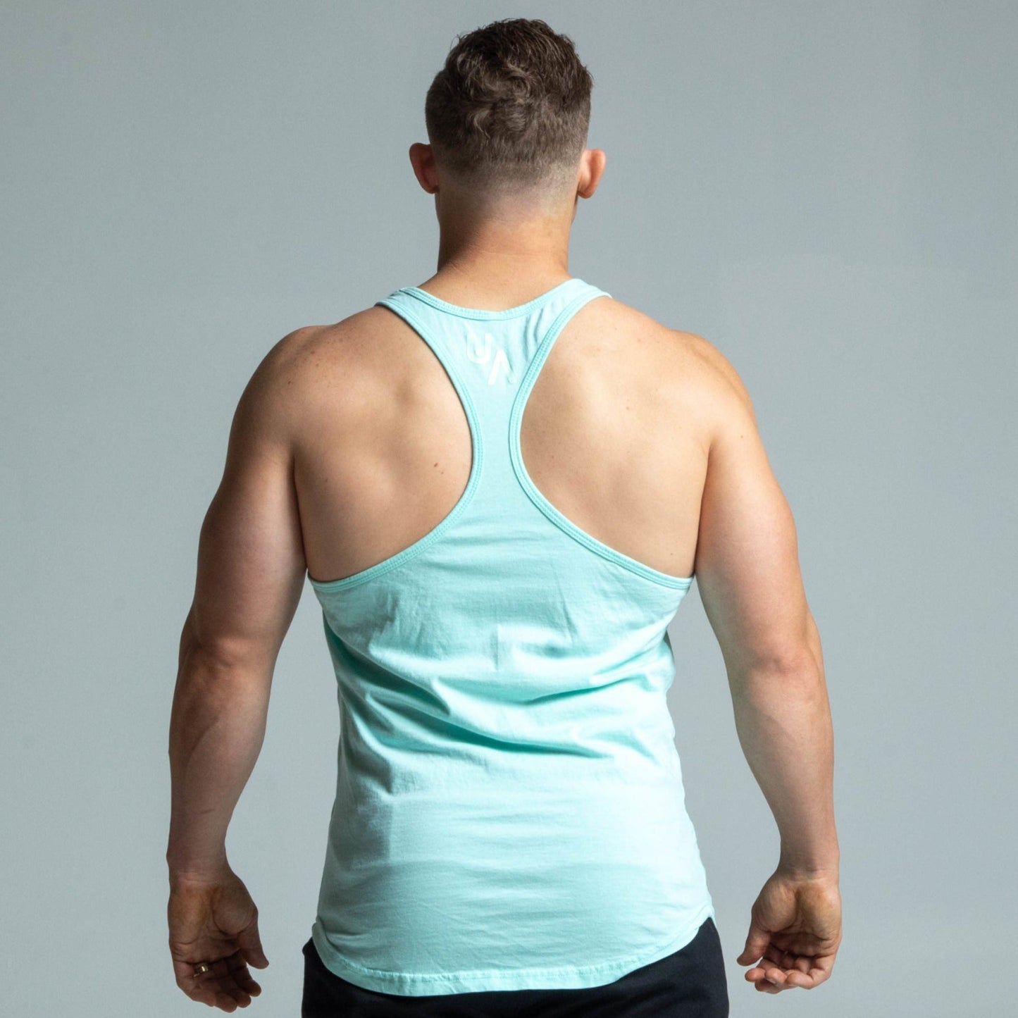 Back view of man wearing baby blue glow stringer tank top