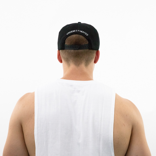 Back view of man wearing black Underestimated Apparel hat